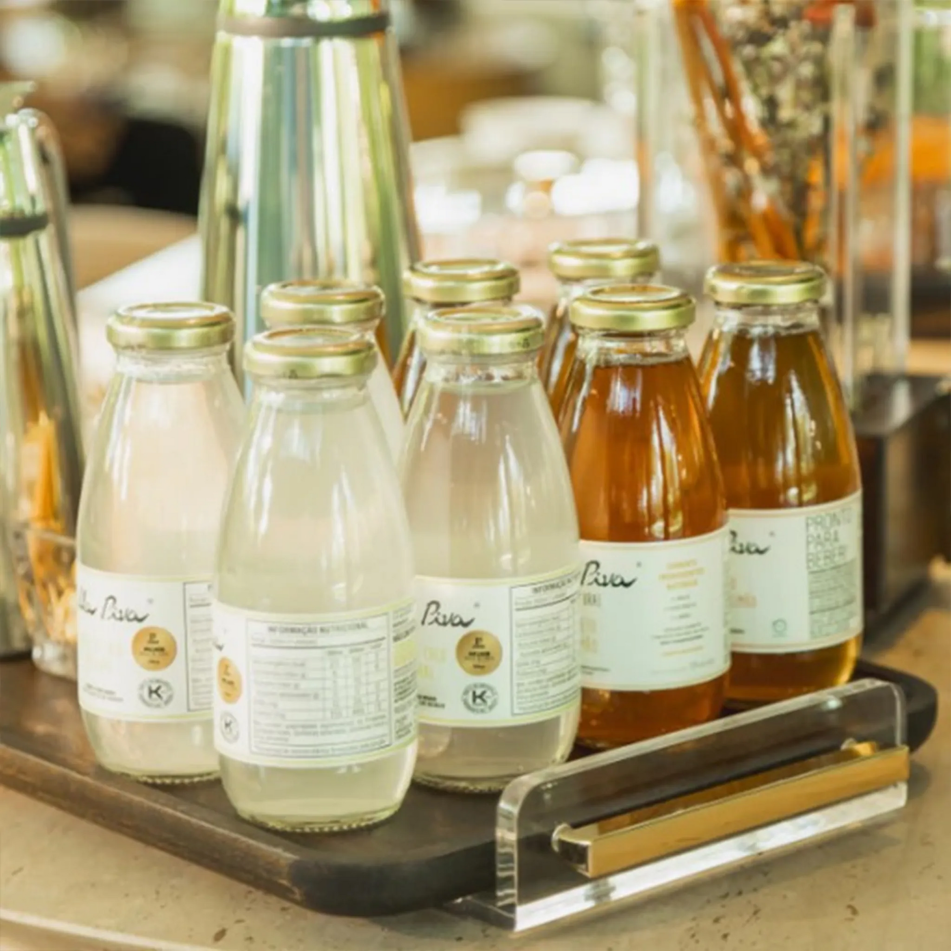 Bandeja Muiracatiara Alenya ambientada com sucos em cima de mesa.