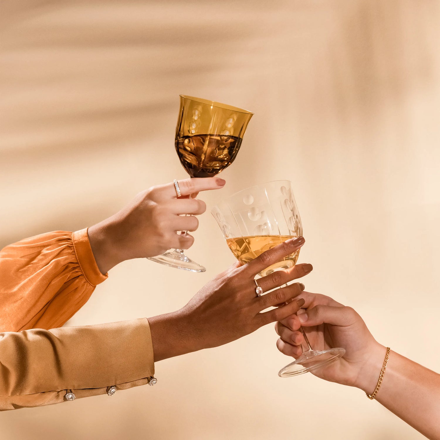 Três pessoas brindando com taças da marca Strauss.