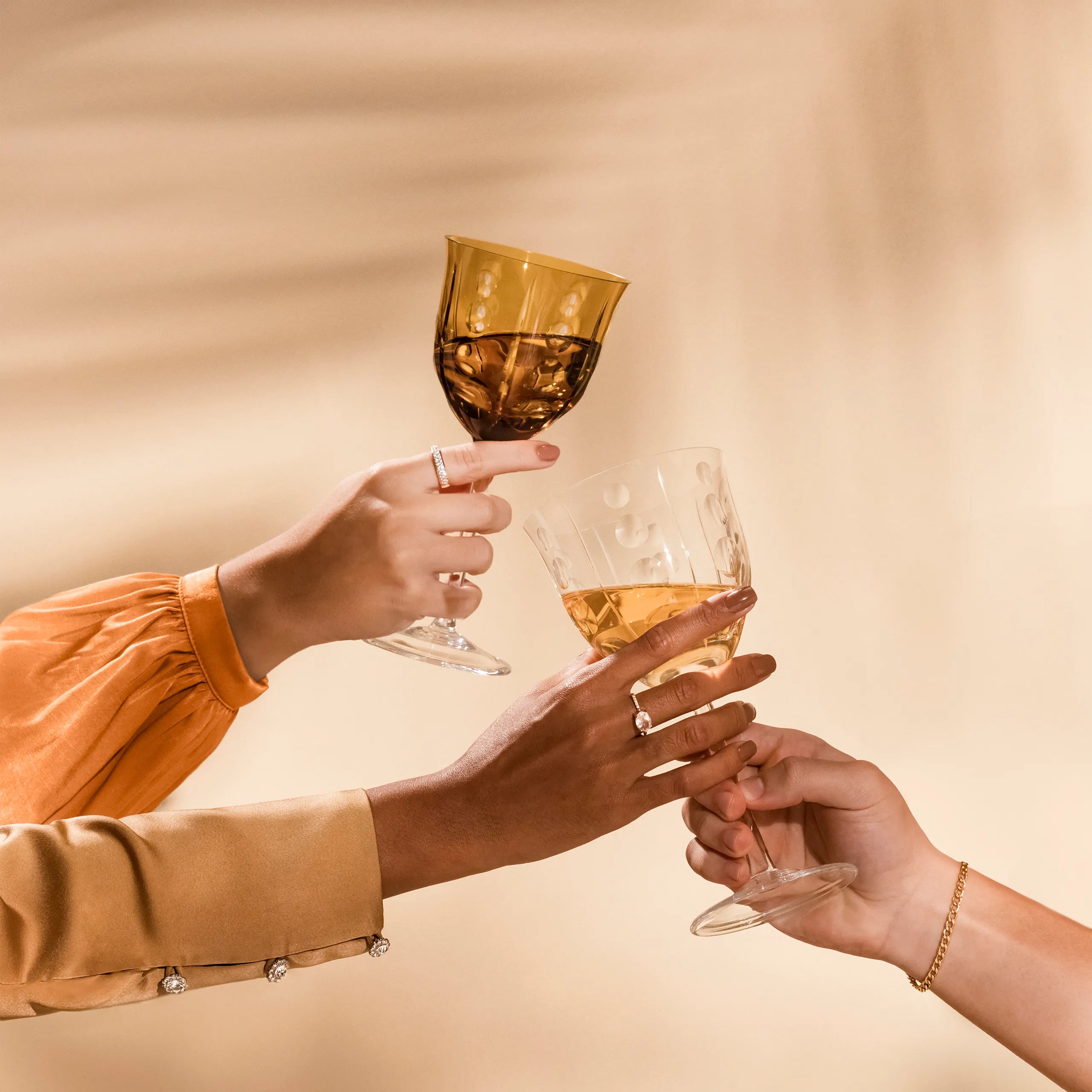 Três pessoas brindando com taças da marca Strauss.