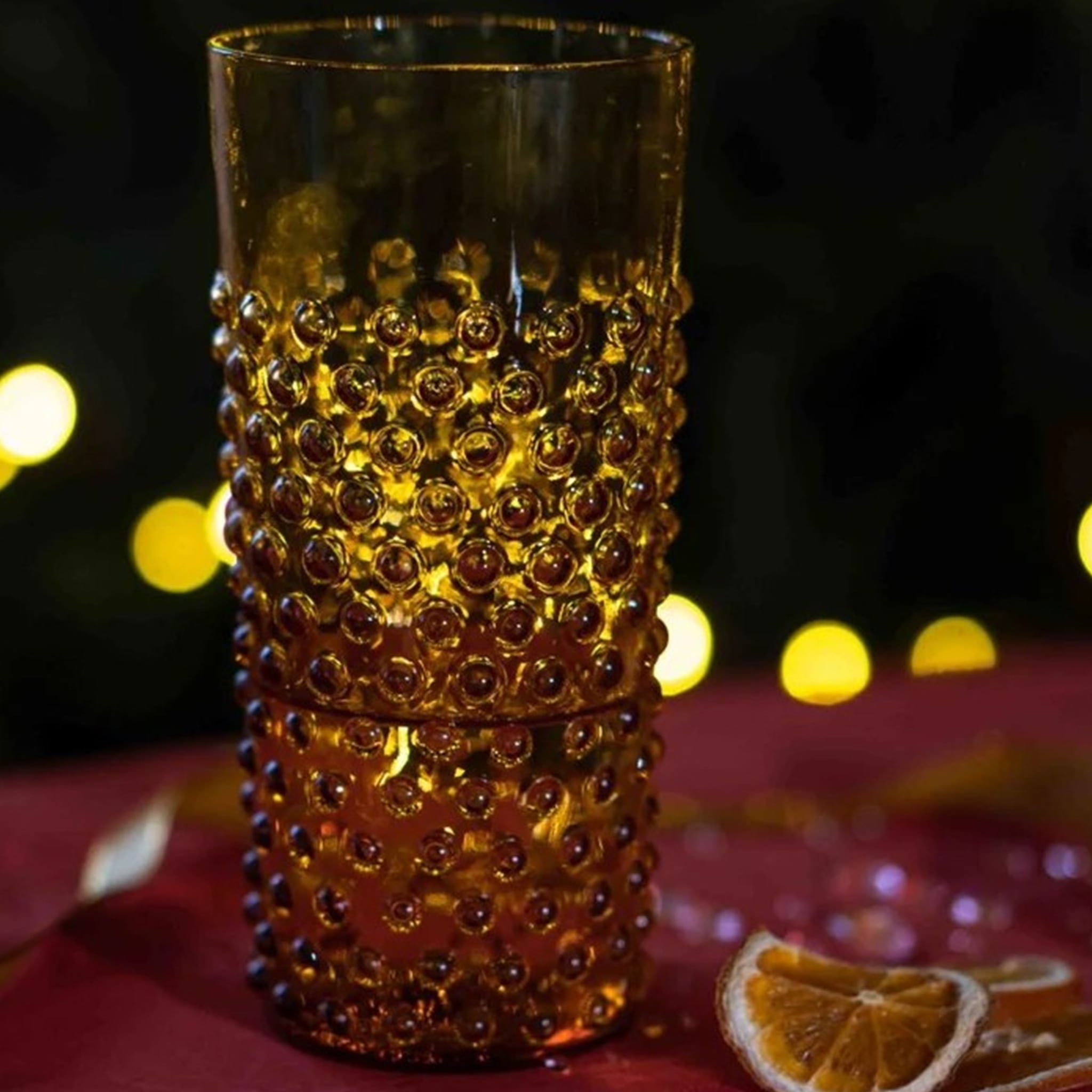 Copo Longo Hobnail Âmbar em ambiente noturno.