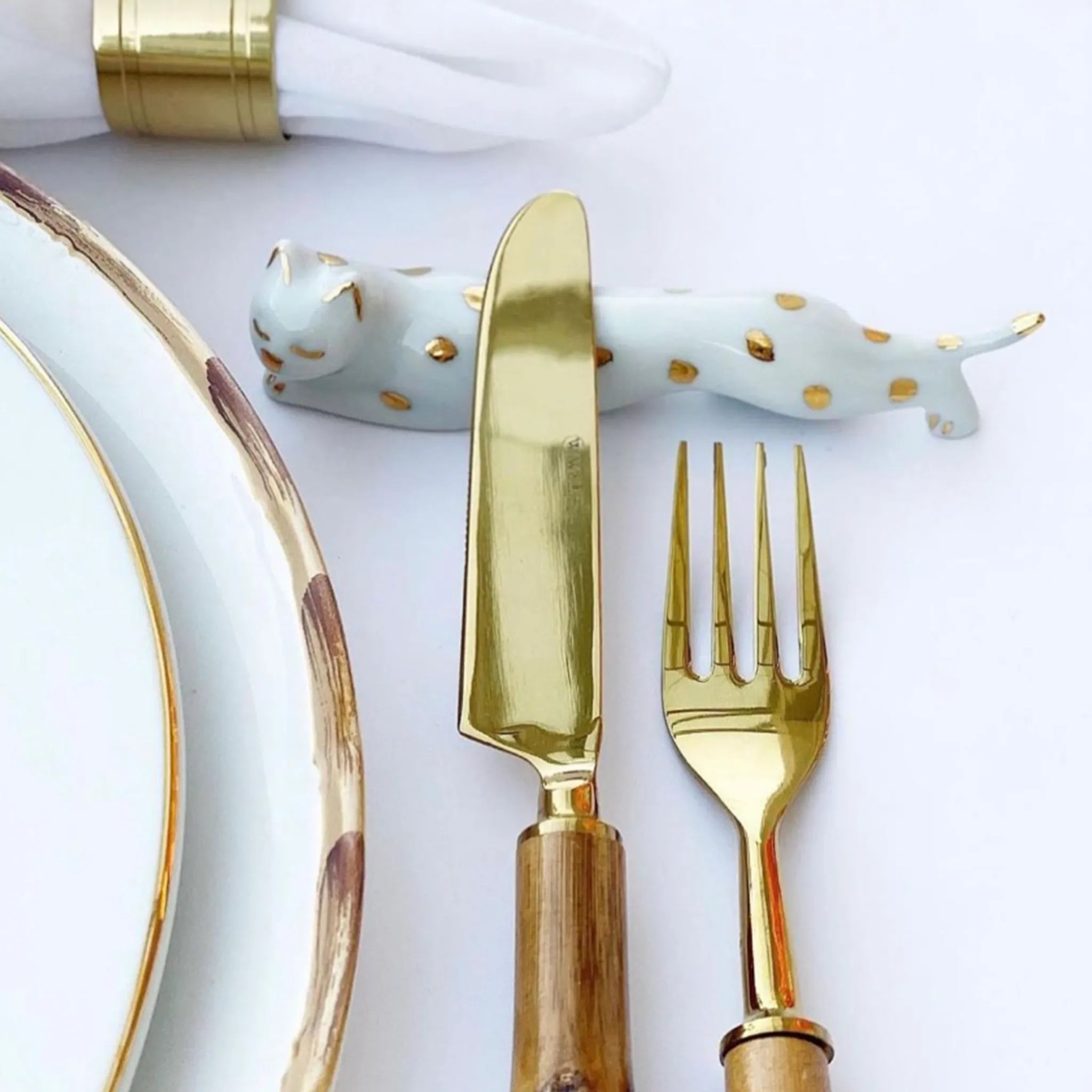 Descanso de Talher Onça com talheres em cima.