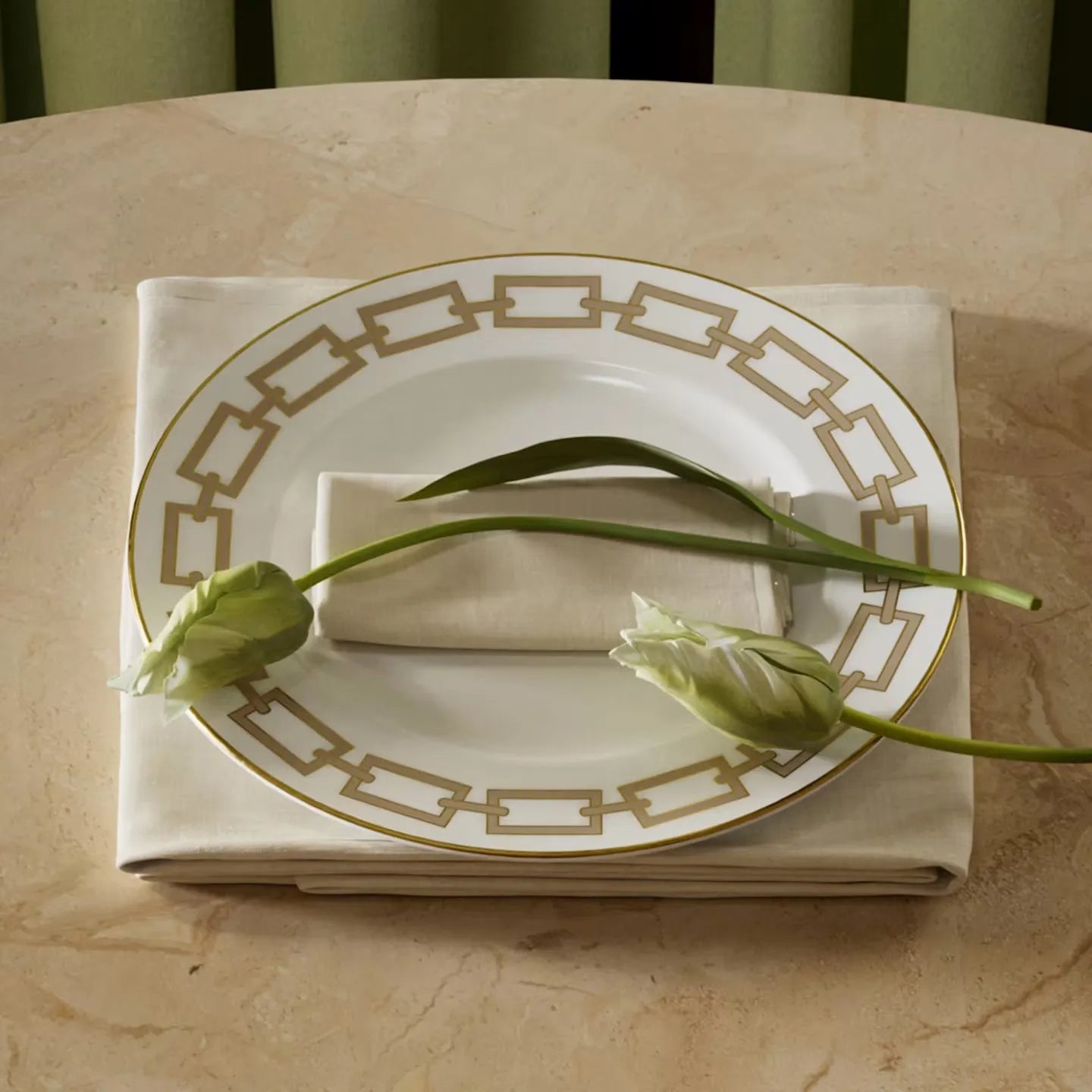 Prato catene sobre mesa de pedra e guardanapo branco, com flores ambientando no prato.