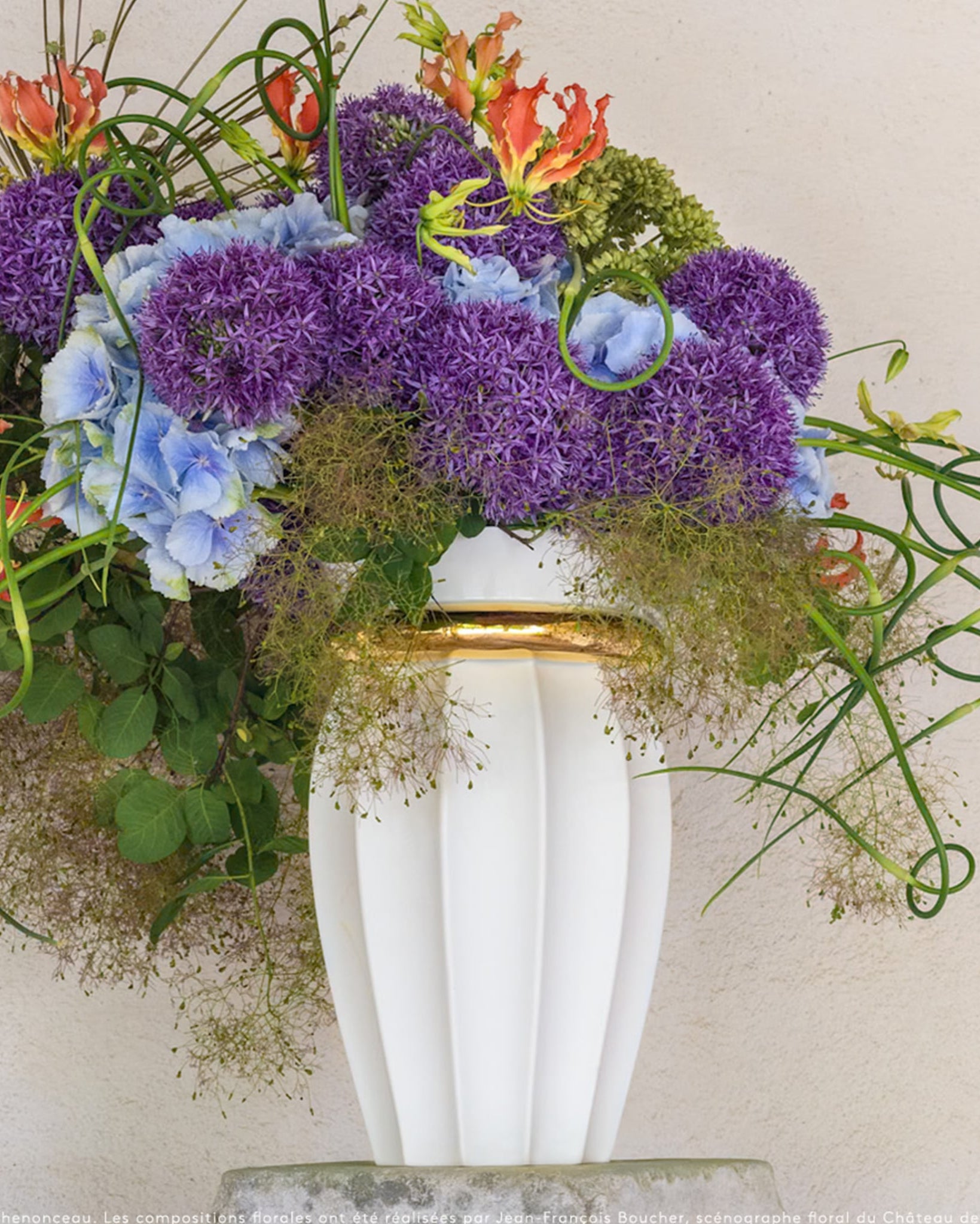 Vaso Ikaria Ouro Limoges G ambientado com flores.