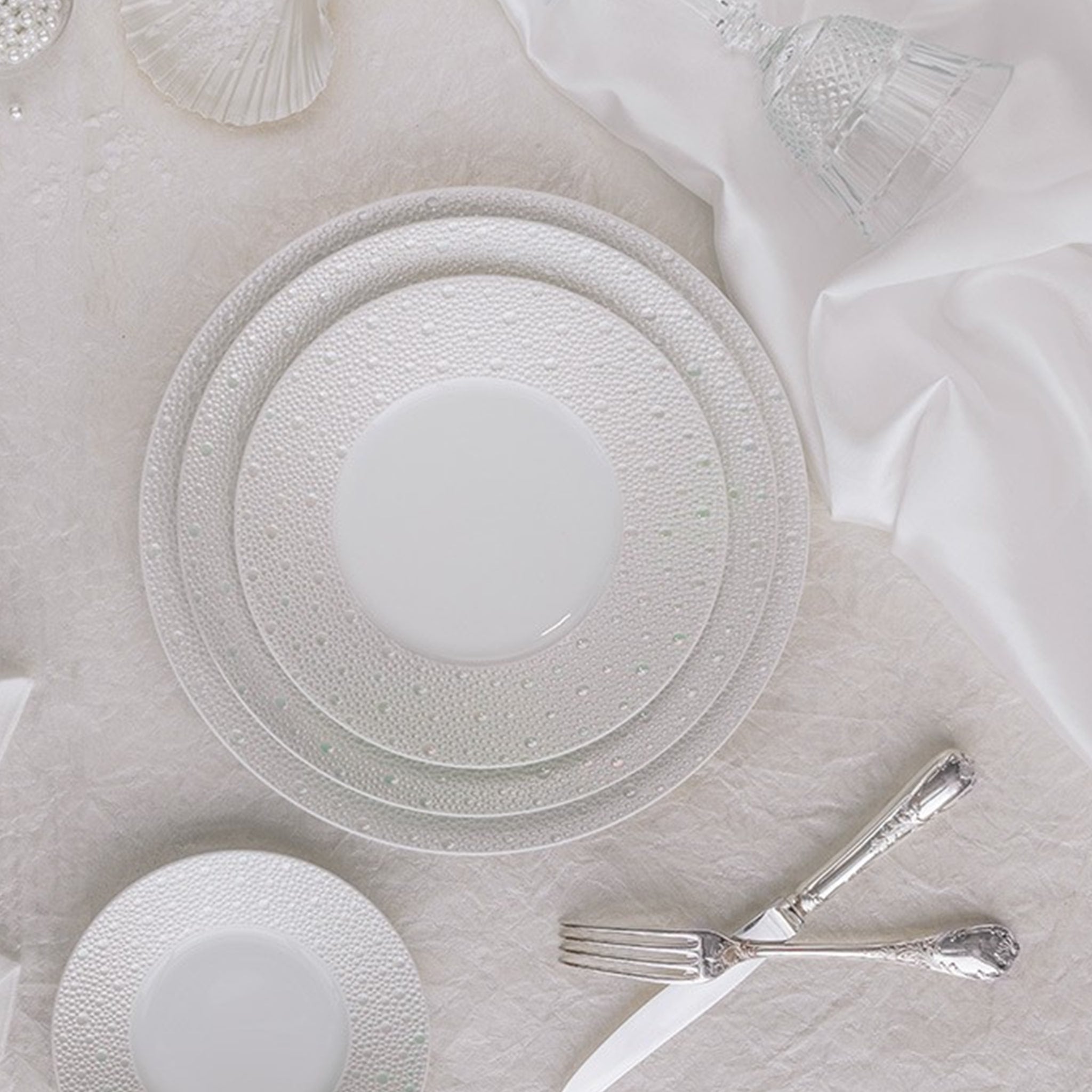 Cena ambientada em mesa com a coleção de pratos Ecume Pérola.