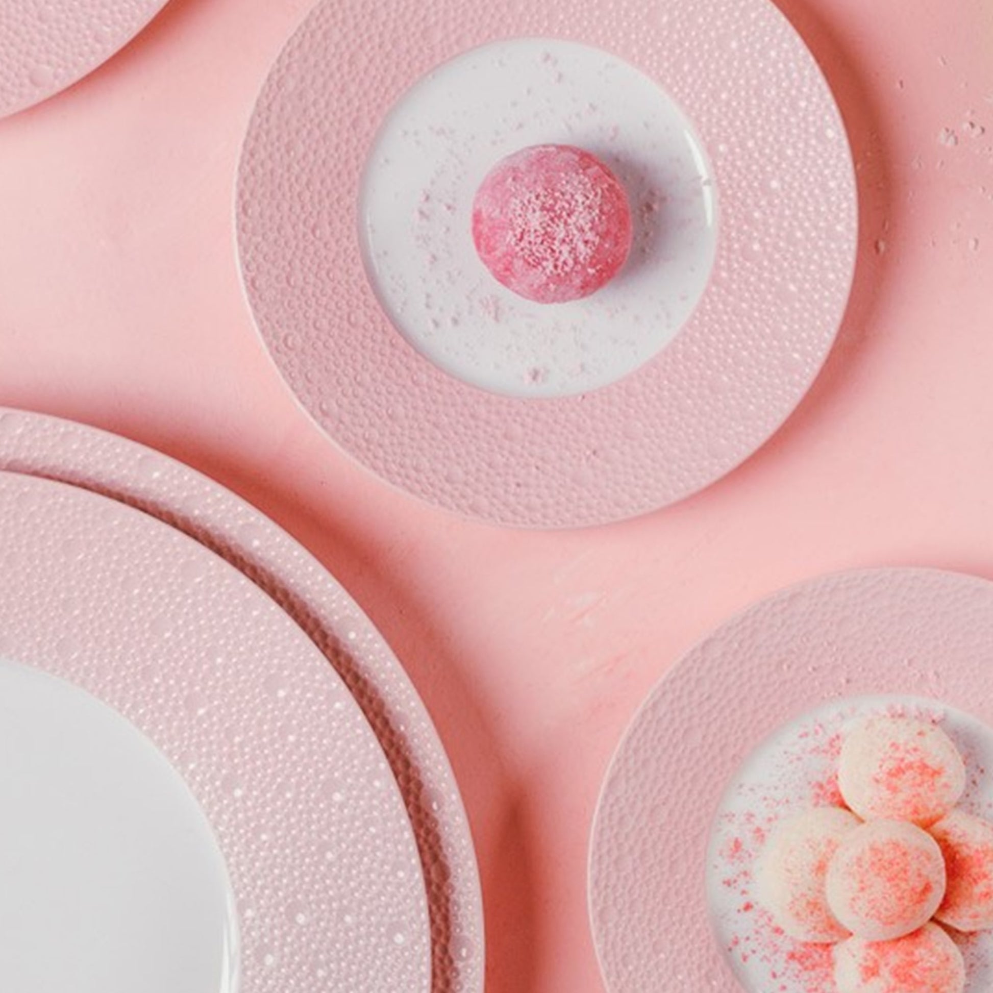 Cena ambientada com pratos da coleção Ecume Rosa e doces do mesmo tom.