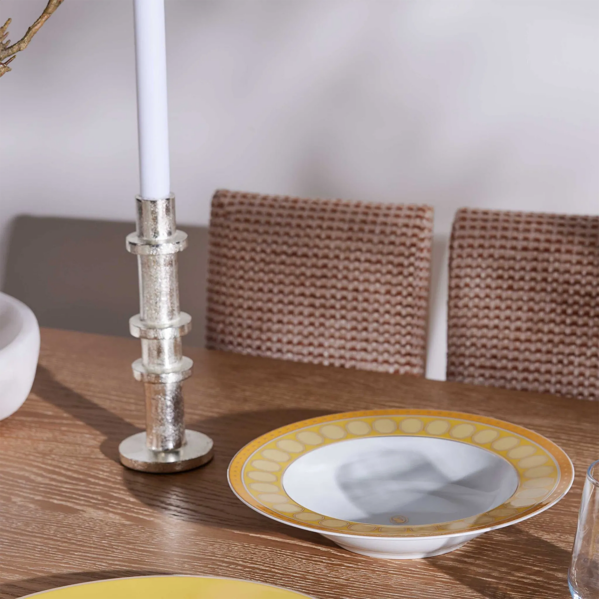 Prato Fundo Swarovski Amarelo em mesa de madeira, com vela ao lado.