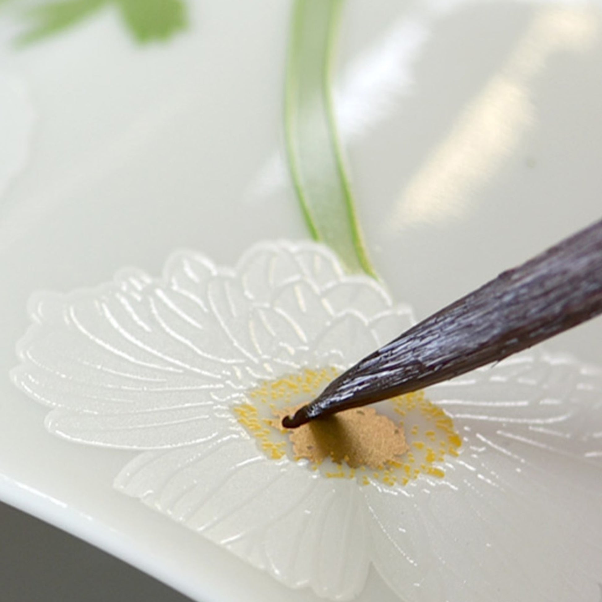 Detalhe da pintura feito à mão com pincel do Prato Pão Praiana.