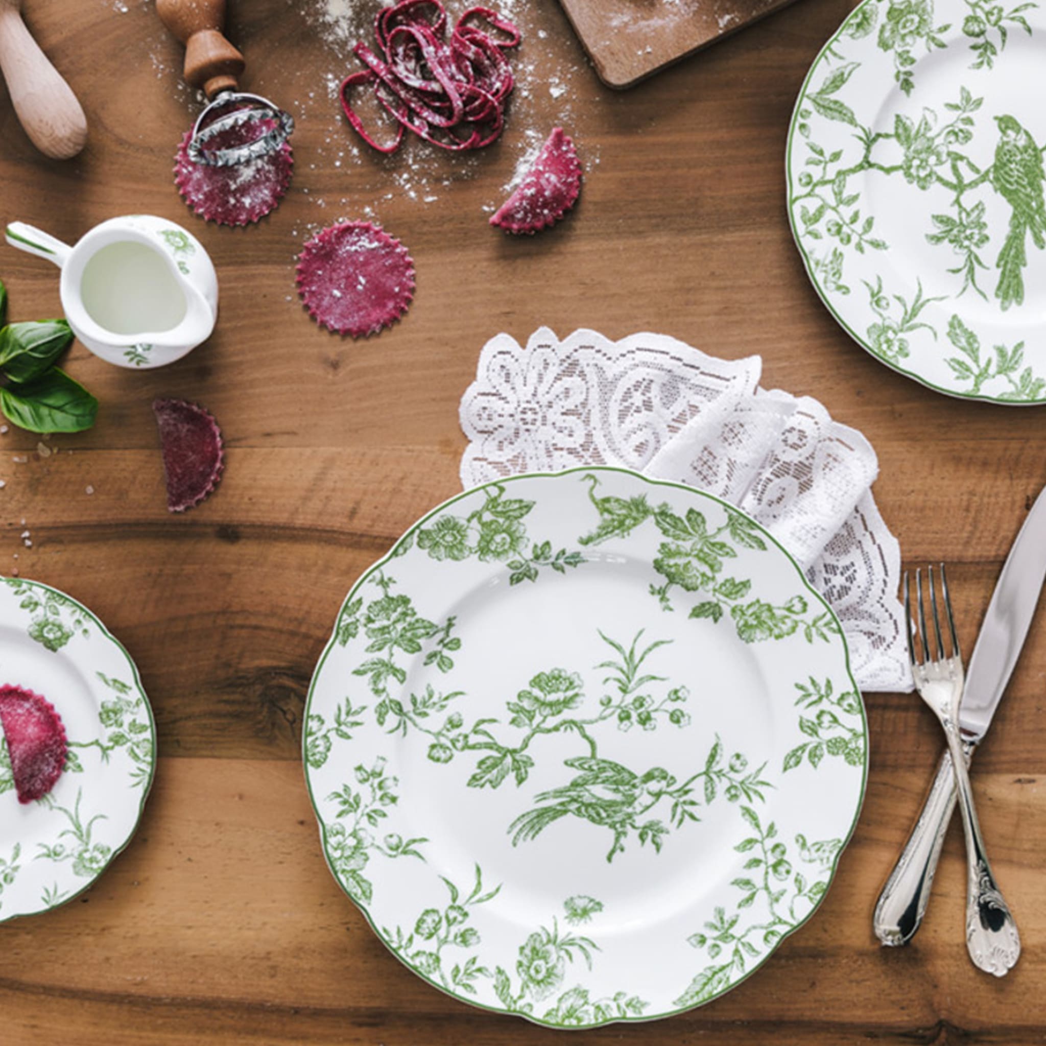 Cena ambientada em mesa de madeira com pratos e itens da coleção Albertine.