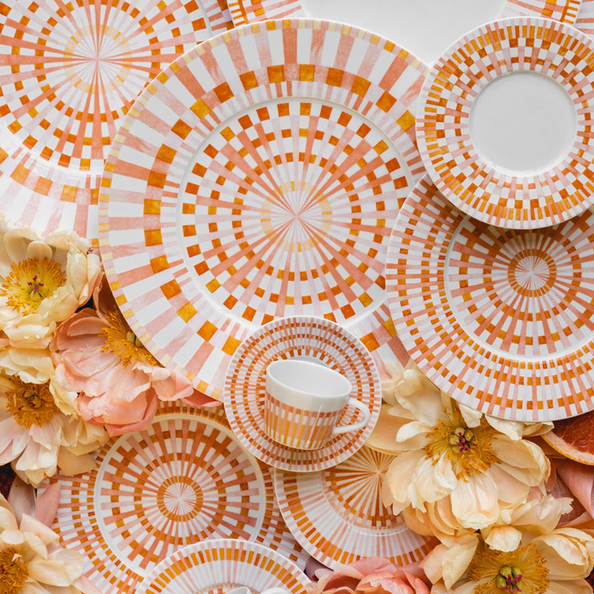 Cena ambientada com flores e pratos que compõe a coleção Terra Rosa.