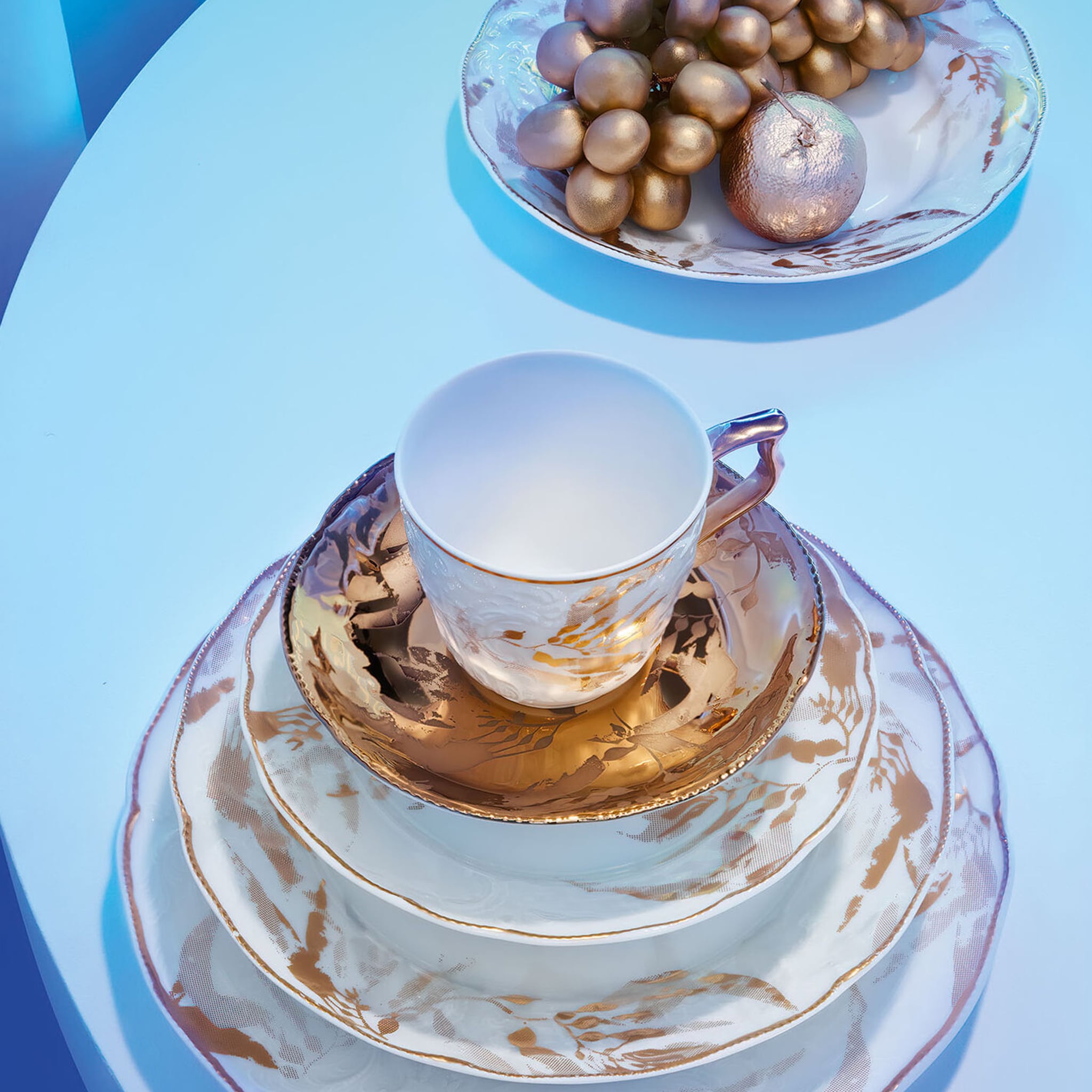 Coleção Heritage Midas em mesa ambientado com adornos dourados.