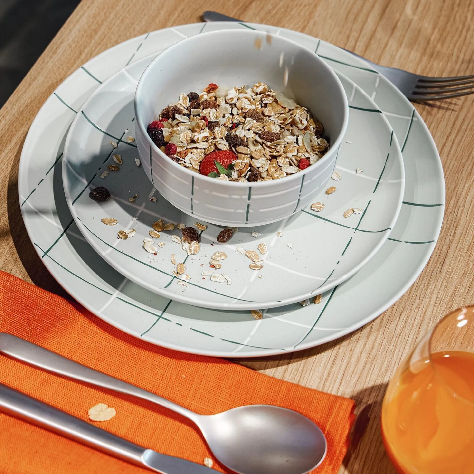 Foto ambientada de pratos e bowl da coleção Karo Verde Claro em cima de mesa de madeira.