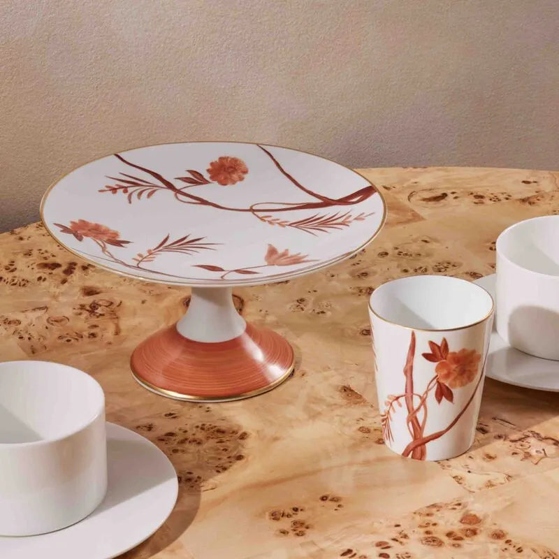 Boleira e copos de cerâmica na marca Marie Dâage Paris, sobre mesa de madeira.