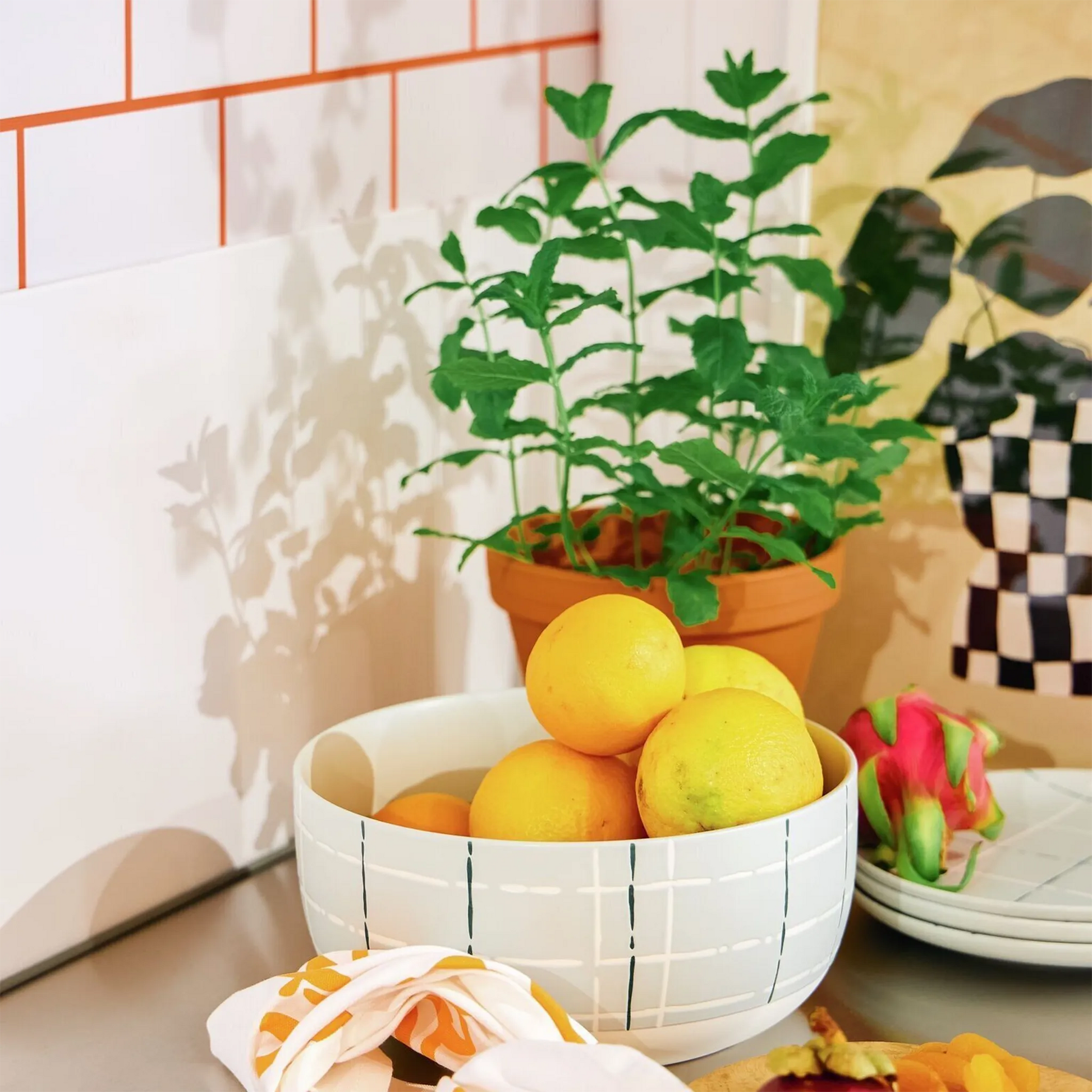 Saladeira Karo Verde Claro ambientada em cozinha com frutas e uma planta ao lado.