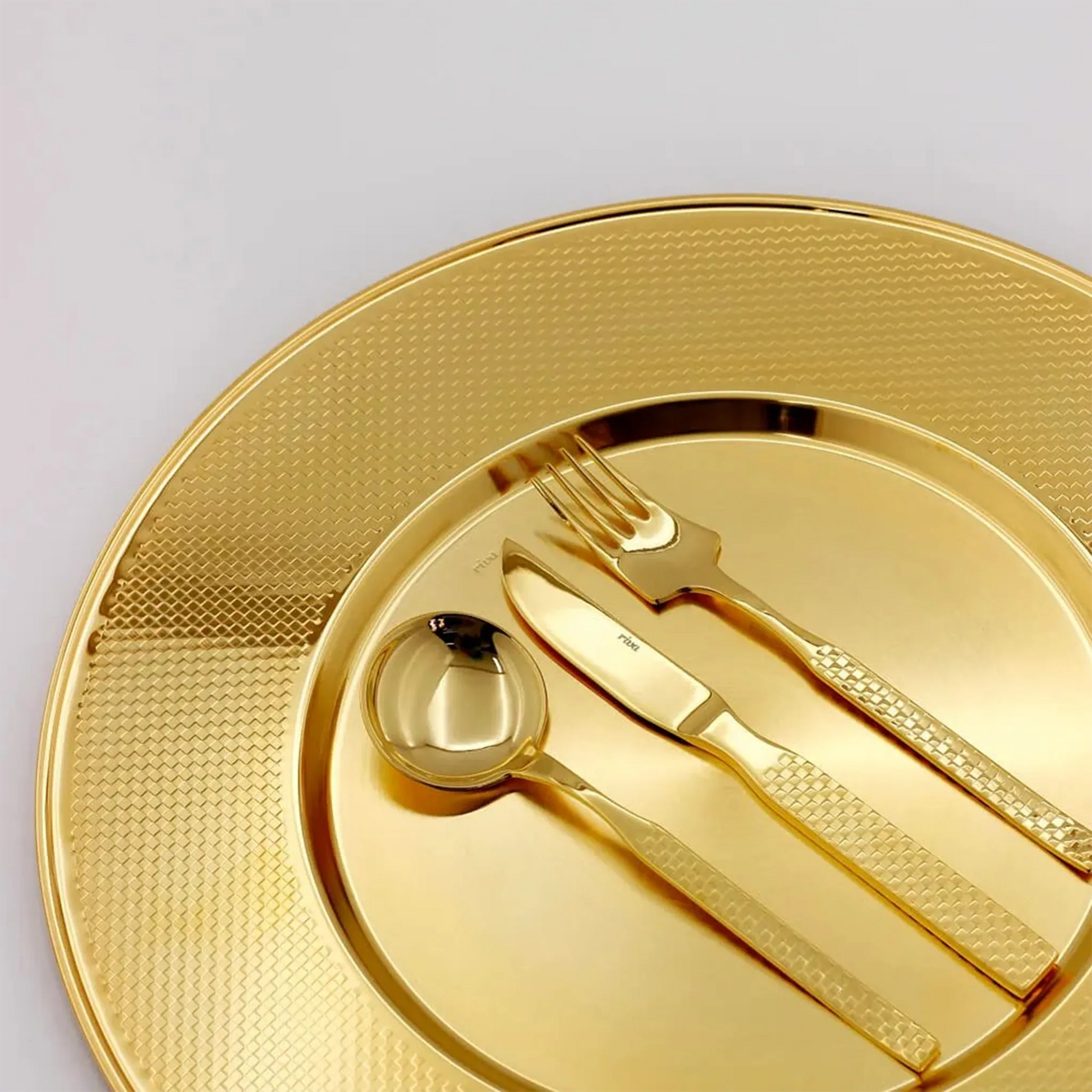 Sousplat Sarezzo Ouro ambientado com talheres.