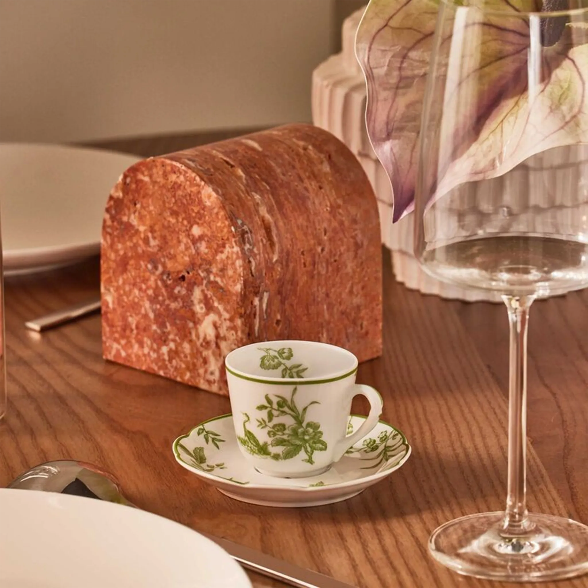 Xícara de Café Albertine ambientada em mesa de madeira, com utensílios de mesa ao redor.