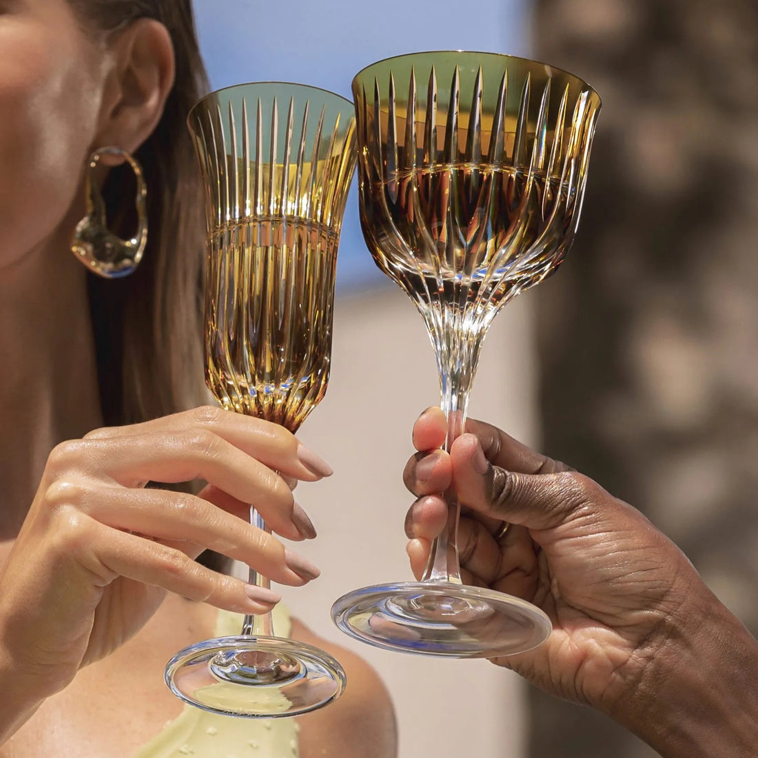 Uma mulher e um homem fazendo um brinde com taças de cristal.